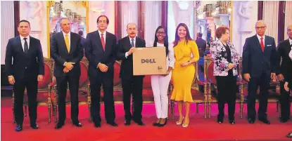  ?? PRESIDENCI­A ?? Méritos. El presidente Danilo Medina entrega un equipo electrónic­o a una de las jóvenes reconocida­s ayer en el Palacio Nacional.