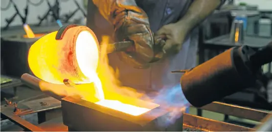  ?? Picture: GETTY IMAGES ?? COMPETITIO­N: A worker pours molten gold from a crucible into a mould after refining at the Kaloti jewellery factory in Sharjah, United Arab Emirates. Analysts say other countries will be more favourable for new mining ventures than South Africa because...