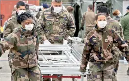  ?? AFP ?? French soldiers install beds at the military field hospital at The Emile Muller Hospital in Mulhouse, eastern France, on Sunday. —