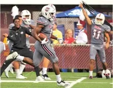  ?? PHOTO BY J. ANTHONY ROBERTS/THE REPUBLICAN ?? FAST START: Marquis Young cruises into the end zone for a 93-yard touchdown on the opening kickoff of UMass’ 49-31 win against Charlotte yesterday in Amherst.