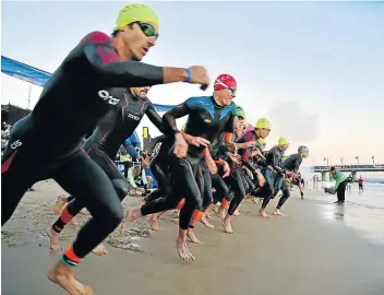  ?? Pictures: EUGENE COETZEE ?? EAGER TO START: Athletes take to the water at Hobie Beach at the start of the Ironman 2019.