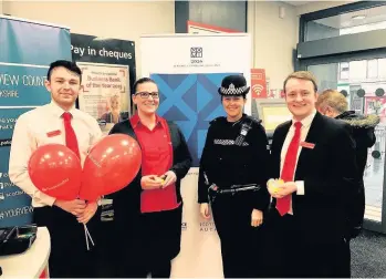  ??  ?? Warning PC Laura Taylor with workers at the Santander branch in Rutherglen Main Street They teamed up to warn about the dangers of bank fraud