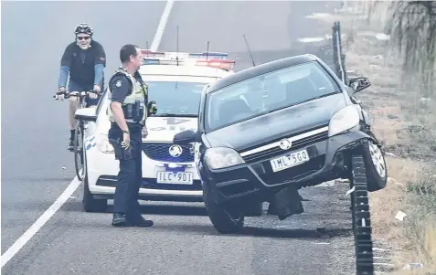  ?? Picture: ALAN BARBER ?? PRECARIOUS POSITION: A car sits on wire barriers along the Portarling­ton Rd between Leopold and Curlewis.