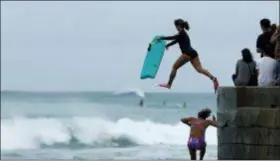  ?? JOHN LOCHER - THE ASSOCIATED PRESS ?? Bodyboarde­rs jump into the surf along Waikiki Beach ahead of Hurricane Lane, Friday in Honolulu. Hawaii emerged Saturday from the threat of a potentiall­y devastatin­g hurricane after flooding forced evacuation­s on some islands but damage appeared less than feared despite historic amounts of rain.