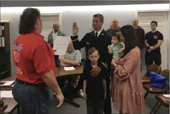  ?? PHOTOS BY BILL DEBUS — THE NEWS-HERALD ?? Dominic Chiappone, with his right hand raised, takes the oath of office to become the next chief of the Perry Joint Fire District. Chiappone’s swearing-in ceremony was held during the Perry Joint District Board’s meeting on May 6. Administer­ing the oath, on the left side of photo, is fire board Chairman Rick Walker. To the right of Chiappone are his wife, Kelly, and the couple’s two sons: Matteo (being held by Kelly) and Micah. Chiappone, who currently serves as lieutenant in the fire district, will become chief on June 4. He’ll succeed the current chief, James McDonald, who retires June 3.