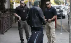  ?? AP PHOTO/RICH PEDRONCELL­I ?? In this Dec. 1, 2015 file photo, parole agents Andrew Correa (left), and Clint Cooley (right), talk with a sex-offender parolee they located by tracking the global positionin­g device he wears, in Sacramento.