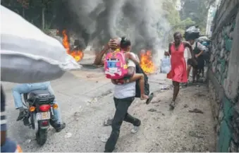  ?? AP ?? Neumáticos encendidos en las calles de Puerto Príncipe afectaron a los ciudadanos.