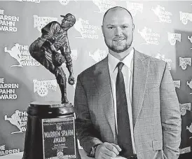  ?? [PHOTO BY NATE BILLINGS, THE OKLAHOMAN] ?? Jon Lester of the world champion Chicago Cubs stands next to the Warren Spahn Award on Thursday night at the Jim Thorpe Museum and Oklahoma Sports Hall of Fame. Lester won the award for being the top left-handed pitcher in baseball for the 2016 season.