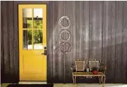  ??  ?? A bright yellow door is a welcoming entry point to the light and roomy pantry/utility room.