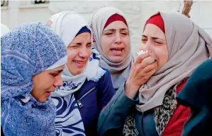  ?? AFP ?? The sisters of Mohamed Amin, a Palestinia­n who was killed by Israeli soldiers, mourn during his funeral in the village of Beit Ula, near Hebron in the Israeli occupied West Bank on Saturday. —