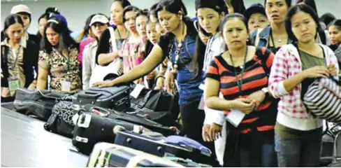  ?? AFP ?? Returning overseas Filipino workers are seen waiting for their luggage beside a baggage carousel at the Ninoy Aquino Internatio­nal Airport.