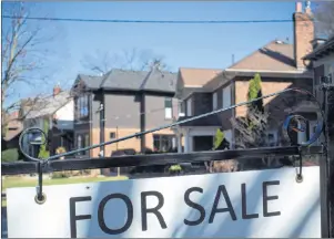  ?? CP PHOTO ?? A “For Sale” sign is shown in front of west-end Toronto homes Sunday, April 9. Home sales in June posted their largest monthly drop in seven years, driven by a plunge in the Greater Toronto market, the Canadian Real Estate Associatio­n said Monday, the...