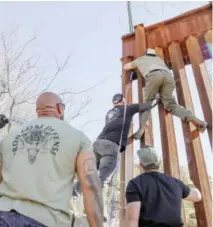  ?? SANDY HUFFAKER/GETTY IMAGES VIA AGENCE FRANCE-PRESSE ?? VOLUNTEERS with Border Vets help erect barbed wire along the United States-Mexico border wall in Jacumba Hot Springs, California as a deterrent. Border Vets is a group of military veterans concerned with the flow of illegal migrants.