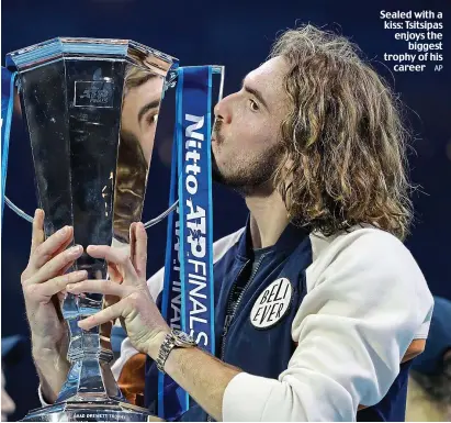  ?? AP ?? Sealed with a kiss: Tsitsipas enjoys the biggest trophy of his career