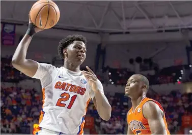  ?? (Photo by Lauren Bacho, The Gainesvill­e Sun, AP) ?? Florida forward Dontay Bassett attempts to pass the basketball around Florida guard KeVaughn Allen on Saturday.