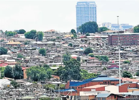  ?? Picture: SIMON MATHEBULA ?? WEALTH GAP: The affluence of Sandton City looms in the background of the township of Alexandra, in Johannesbu­rg