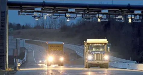  ?? Darrell Sapp/Post-Gazette ?? A truck gets flashed by light as it passes through the “cashless tolling system” at the Findlay Connector section of Turnpike 576, between routes 60 and 22, on Thursday in Findlay. Drivers can either use E-ZPass or have a photo taken of their license plate and receive a bill by mail.