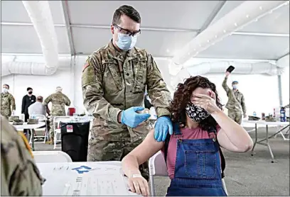  ?? LYNNE SLADKY / AP ?? Leanne Montenegro, 21, covers her eyes as she doesn’t like the sight of needles, while she receives the Pfizer COVID-19 vaccine Monday at a FEMA vaccinatio­n center at Miami Dade College in Miami.