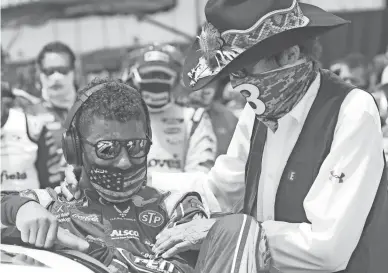  ??  ?? Team owner Richard Petty, right, meets with driver Bubba Wallace prior to the start of the NASCAR Cup Series race at Talladega Superspeed­way in Talladega, Ala., on Monday.