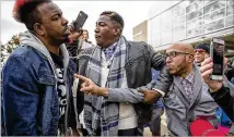  ?? ALYSSA POINTER / ALYSSA.POINTER@AJC.COM ?? Trump supporters Tony Smith (right) of College Park and Jerrod Brown (center) of Savannah engage in a shouting match with protester Chris Mungin.
