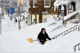  ?? GREG WOHLFORD / ERIE TIMES-NEWS ?? Rochelle Carlotti, 28, shovels the steps Tuesday near her home in Erie, Pa. More than 65 inches of snow have fallen on the city since Christmas Eve.
