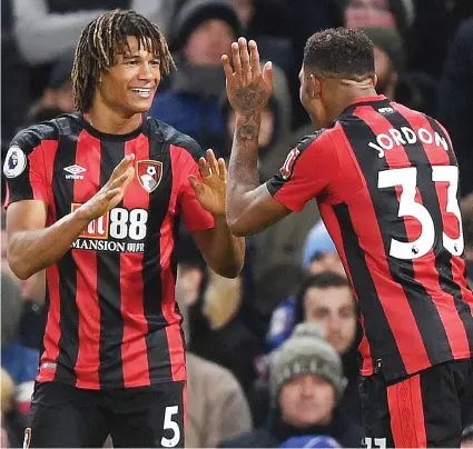  ??  ?? Shock troops: Ake and Ibe celebrate Bournemout­h’s third as Conte cuts a despondent figure (below)