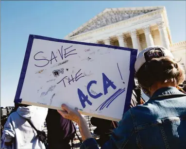  ?? Nicholas Kamm / Getty Images ?? A demonstrat­or holds a sign in front of the US Supreme Court in Washington, DC, on November 10, 2020, as the high court opened arguments in the long-brewing case over the constituti­onality of the 2010 Affordable Care Act, under which then-president Barack Obama's government sought to extend health insurance to people who could not afford it.