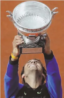  ?? AP PHoTo ?? FEAT OF CLAY: Rafael Nadal raises the trophy after beating Stan Wawrinka in straight sets to win his 10th career French Open title yesterday in Paris.