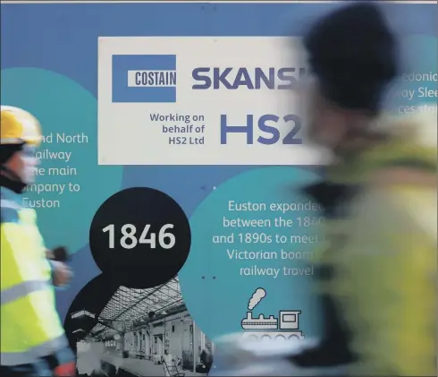  ?? PICTURE: TOLGA AKMEN/AFP/GETTY ?? STOP AND START: Workers stand near a sign outide a constructi­on site for a section of the HS2 railway project, at London’s Euston station.