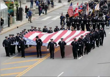  ?? JONATHAN TRESSLER — THE NEWS-HERALD ?? Officers from a variety of public safety agencies carry a huge American flag down Lakeside Avenue toward the Greater Cleveland Peace Officers Memorial at Huntington Park May 19 during the 32nd annual Greater Cleveland Peace Officers Memorial Parade and...