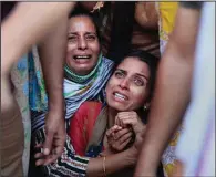  ?? (File Photo/ap/channi Anand) ?? Aradhana (center), wife of Deepak Chand, a schoolteac­her who was killed in Kashmir, mourns Oct. 8 before his cremation in Jammu, India. Assailants fatally shot two schoolteac­hers in Indian-controlled Kashmir in a sudden rise in targeted killings of civilians in the disputed region, police said.