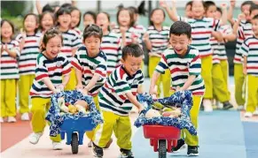  ??  ?? To the finish line: Children pushing mini carts carrying produce at a kindergart­en in Changxing county in Zhejiang province. Children took part in activities to learn more about agricultur­e as the country celebrates the harvest festival. — China Daily/ANN