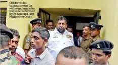  ??  ?? CDS Ravindra Wijegunara­tne (in white uniform) who surrendere­d himself to the Colombo Fort Magistrate­s Court
