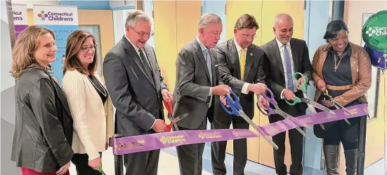  ?? Photos by Alex Putterman/Hearst Connecticu­t Media ?? Gov. Ned Lamont cuts a ribbon to celebrate a new medical-psychiatri­c unit at Connecticu­t Children’s, flanked by state and hospital officials.