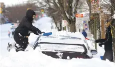  ?? RICKKINTZE­L/THE MORNING CALL ?? Angela Rodriguez, of Bethlehem, takes a snow brush and attempts to clean off her vehicle parked along Broad Street on Thursday morning in the city.