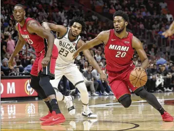  ?? LYNNE SLADKY / AP ?? Heat forward Justise Winslow (right) drives as Milwaukee’s Sterling Brown (center) defends during Miami’s 97-79 victory. Seeing his first action after missing 14 games, Winslow had 3 points, 4 rebounds and 4 assists.