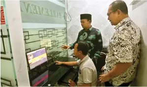  ?? BOY SLAMET/JAWA POS ?? MEMUDAHKAN: Sullamul Hadi Nurmawan (tengah) melihat aplikasi e-Parlemen Delta di ruang DPRD Sidoarjo kemarin.