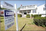  ??  ?? In this file photo, a real estate brokerage sign stands in front of a house in Norwood, Massachuse­tts. (AP)