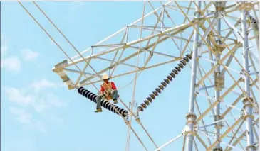  ?? HENG CHIVOAN ?? Electricia­ns prepare high tension power cables on Hun Sen Blvd in the capital’s Meanchey district on August 27.