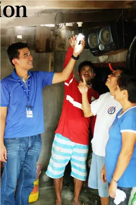  ??  ?? With a mission of brightenin­g community, an SM Volunteer installs an LED bulb at a residence in Sta. Cruz, Paombong in Bulacan. SM City Marilao donated over a hundred energy-saving LED bulbs to bring sustainabl­e light into the community.