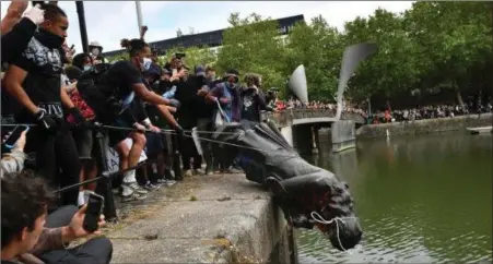  ??  ?? The statue of Edward Colston, by Slane man John Cassidy, is dumped in the harbour in Bristol during protests.