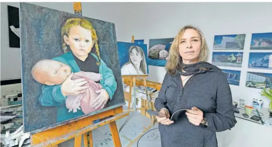  ?? FOTO: IRIS MAURER ?? Julia Aatz vor einigen ihrer Porträts in ihrem Atelier im KuBa am Eurobahnho­f. Sie wählt gern Mitglieder ihrer Familie als Vorlage für ihre Menschen-Bilder.