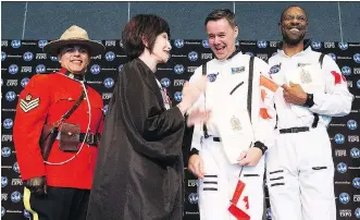  ?? GREG SOUTHAM ?? RCMP Sgt. Alexander DaSilva, left, and presiding official Elexis Schloss pose with Daniel Straka and Ali Finley, who dressed in NASA suits for their citizenshi­p ceremony at Edmonton Expo Centre on Friday.