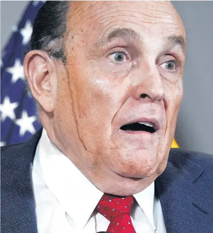  ??  ?? Dye appears to trickle down the face of Rudy Giuliani as he speaks at a news conference at the Republican National Committee HQ in Washington DC