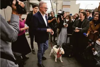  ?? Rick Rycroft / Associated Press ?? Labor Party leader Anthony Albanese leaves his polling station with his dog, Toto, after he voted in Sydney. Prime Minister Scott Morrison quickly conceded defeat in the contest.