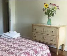  ?? ?? a vintage dresser adorned with a bouquet of flowers in a vase converted from an oversized novelty salt shaker in a bedroom at Weintraub’s home.