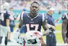  ?? LYNNE SLADKY — THE ASSOCIATED PRESS FILE ?? In this 2019file photo, New England Patriots wide receiver Antonio Brown stands on the sidelines during the first half against the Dolphins. Brown has agreed to return to the NFL with the Tampa Bay Buccaneers on a one-year deal, according to a person with knowledge of the move.