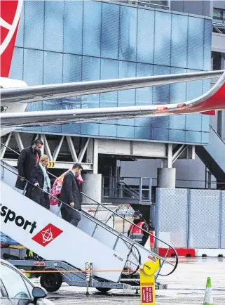  ?? PHOTOS: MARK CONDREN ?? Return: Lisa Smith (below, right) is escorted off the Turkish Airlines flight at Dublin Airport. Below, left, she is led to a waiting vehicle.