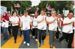  ?? — GLENN GUAN and NG KOK LEONG/
The Star ?? Walking the talk:
Participan­ts getting set to be flagged off for the unity walk by Selangor Ruler Sultan Sharafuddi­n Idris Shah and (inset) Sultan Sharafuddi­n and Tengku Permaisuri Norashikin leading more than 6,000 Malaysians on the walk. With them...