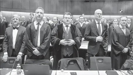  ?? Swen Pfoertner Associated Press ?? THE TRIAL of a lawsuit against Volkswagen was moved to the civic center in Braunschwe­ig, Germany, to allow room for the lawyers and investors who want to attend. Above, plaintiffs’ attorney Andreas W. Tilp, center, waits for the trial to get underway Monday.